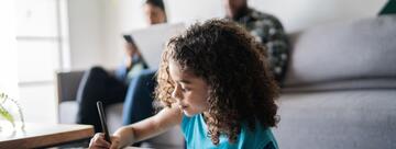 Child studying in front of seated parents