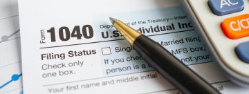 Form 1040 with a pen and calculator